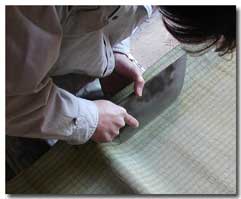 包丁で畳表の折り目を押さえ曲げる。